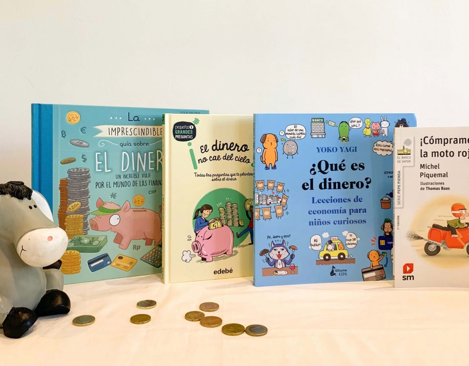 foto en la que aparecen cuatro libros sobre dinero, una hucha y monedas